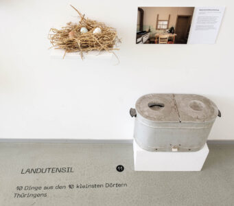3 Hühnereier und Stroh aus Meusebach (96 Einwohner). Übrigens: Einer derer von Meusebach wird heute in Texas verehrt. Daneben: Speisewarmhaltevorrichtung aus Kleinbockedra (37 Einwohner), der kleinsten Gemeinde Ostdeutschlands. Foto: Wolfgang Grau LANDUTENSIL - Dinge aus den zehn kleinsten Dörfern Thüringens